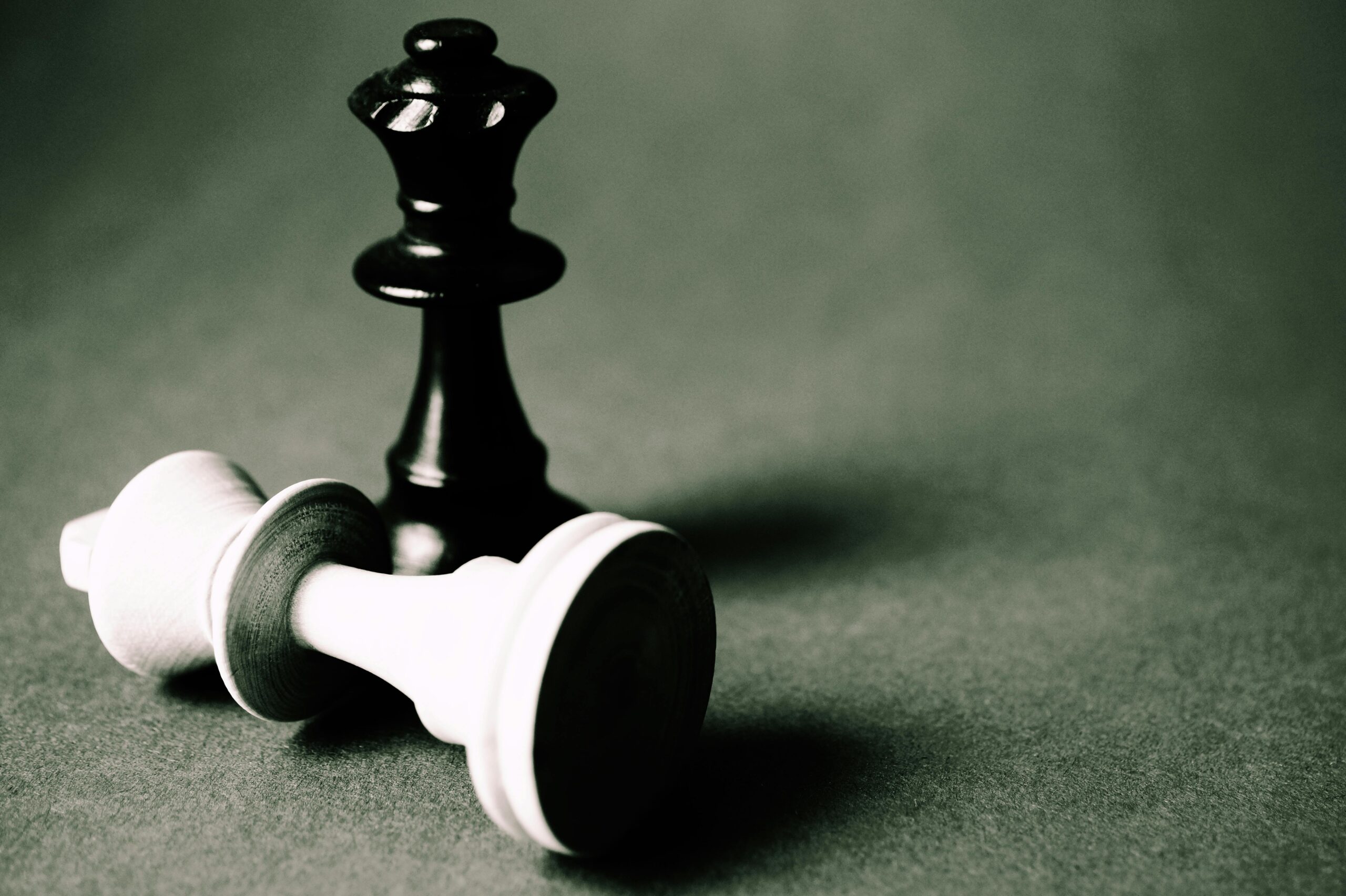 Close-up of chess pieces illustrating strategy and challenge in black and white tones.